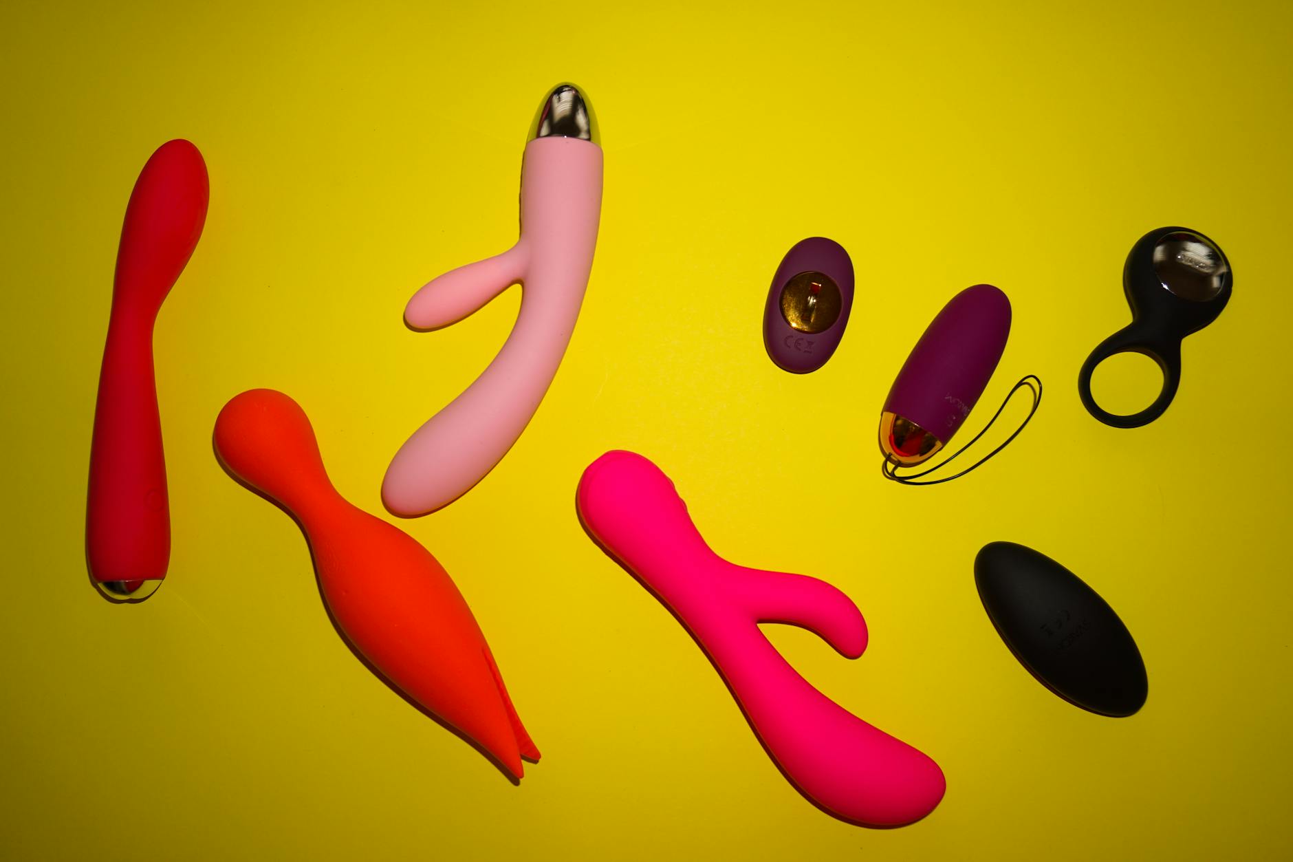 Gros plan d'une main tenant un vibromasseur contre un fond violet minimaliste, mettant en avant la sensualité moderne